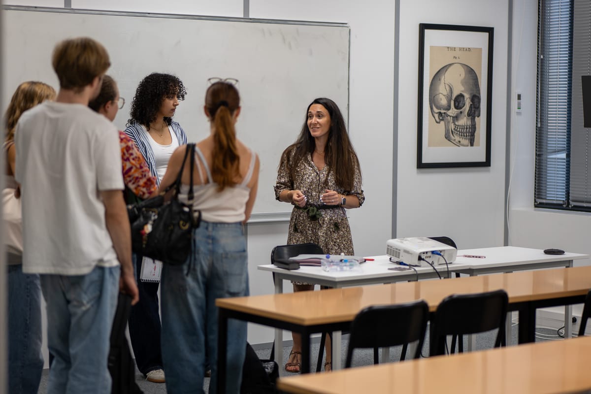 Amélie, directrice de Cours Agora Lyon Sud, discute avec des étudiants dans une salle de cours.