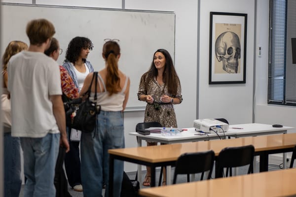 Amélie, directrice de Cours Agora Lyon Sud, discute avec des étudiants dans une salle de cours.